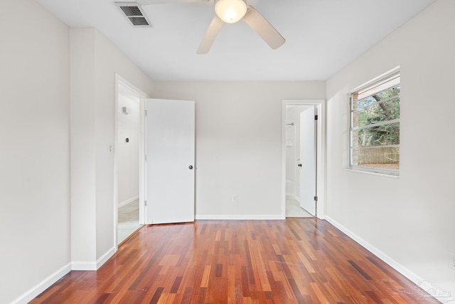 unfurnished bedroom with ceiling fan, connected bathroom, and dark hardwood / wood-style flooring