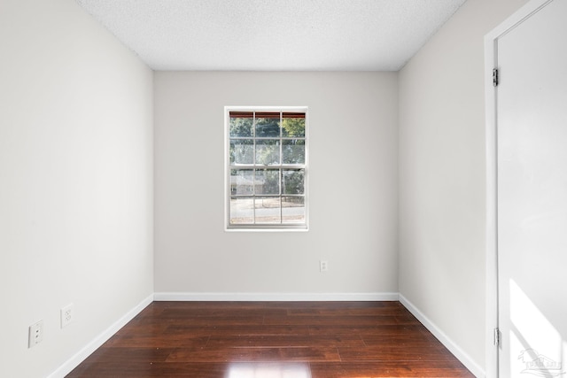 unfurnished room featuring dark hardwood / wood-style floors and a textured ceiling