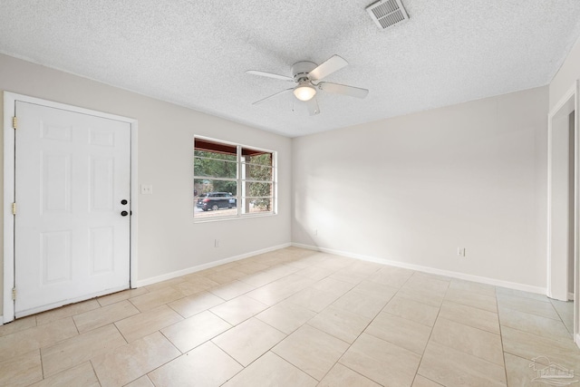 empty room with light tile patterned floors, a textured ceiling, and ceiling fan