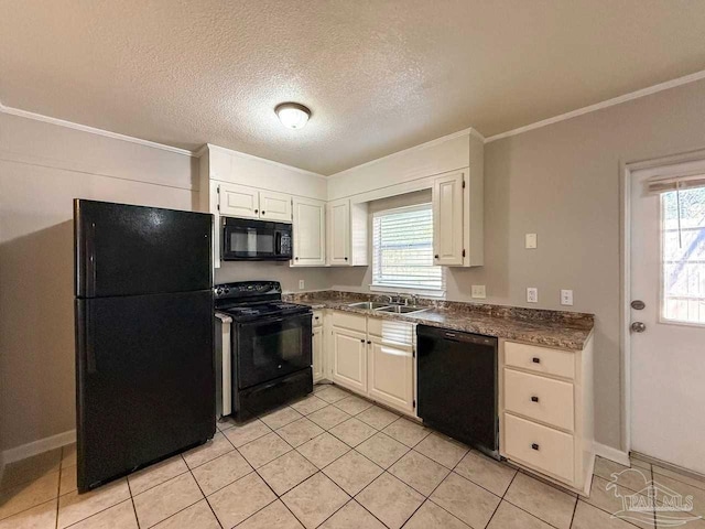 kitchen featuring light tile patterned flooring, dark countertops, a healthy amount of sunlight, and black appliances