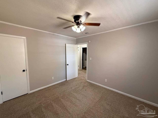 unfurnished bedroom with crown molding, a textured ceiling, visible vents, and carpet flooring