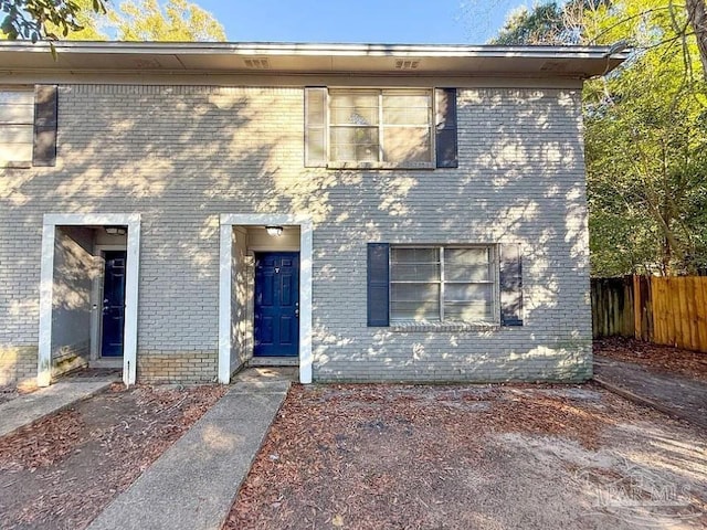 view of front facade with fence and brick siding