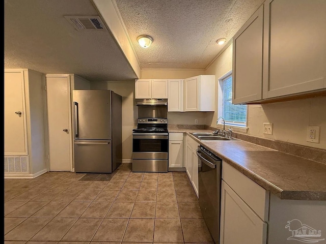 kitchen with a textured ceiling, visible vents, appliances with stainless steel finishes, a sink, and under cabinet range hood