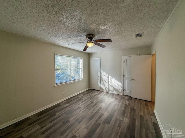 unfurnished room with ceiling fan, dark wood-style flooring, a textured ceiling, visible vents, and baseboards