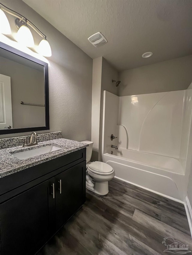 4483 Watkins St, Pace, FL 32571 - bathroom with wood finished floors, vanity, shower / tub combination, toilet, and a textured ceiling