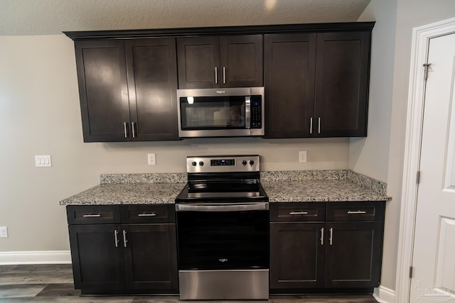 4483 Watkins St, Pace, FL 32571 - kitchen featuring appliances with stainless steel finishes, baseboards, wood finished floors, and light stone counters