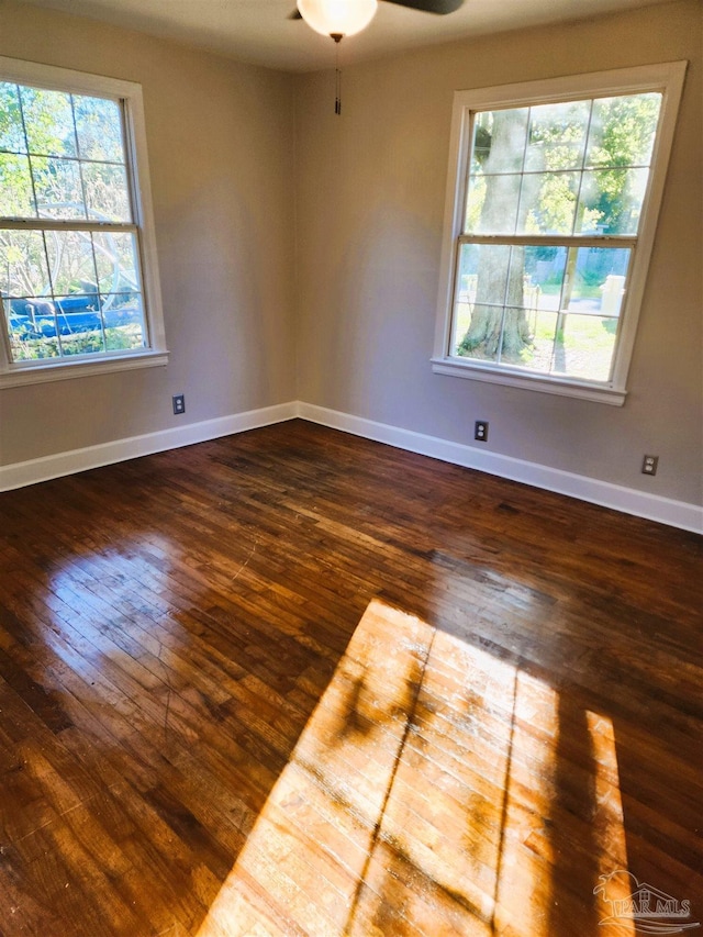 unfurnished room with dark hardwood / wood-style flooring and ceiling fan