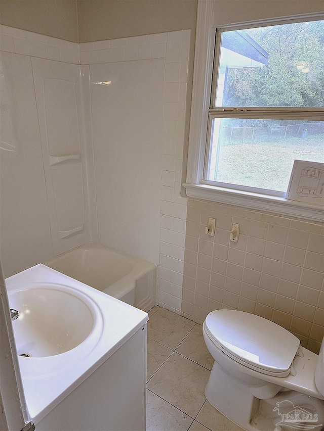 bathroom with tile patterned floors, vanity, a healthy amount of sunlight, and toilet