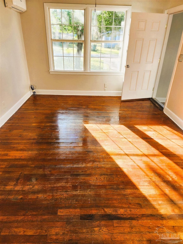 unfurnished room with dark hardwood / wood-style flooring and a wall mounted air conditioner