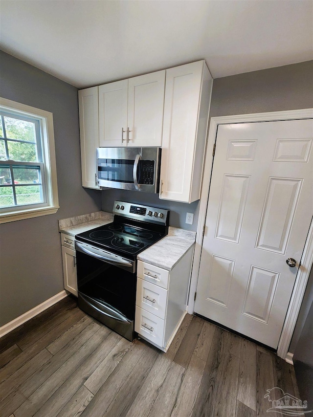 kitchen featuring white cabinetry, dark hardwood / wood-style flooring, and appliances with stainless steel finishes