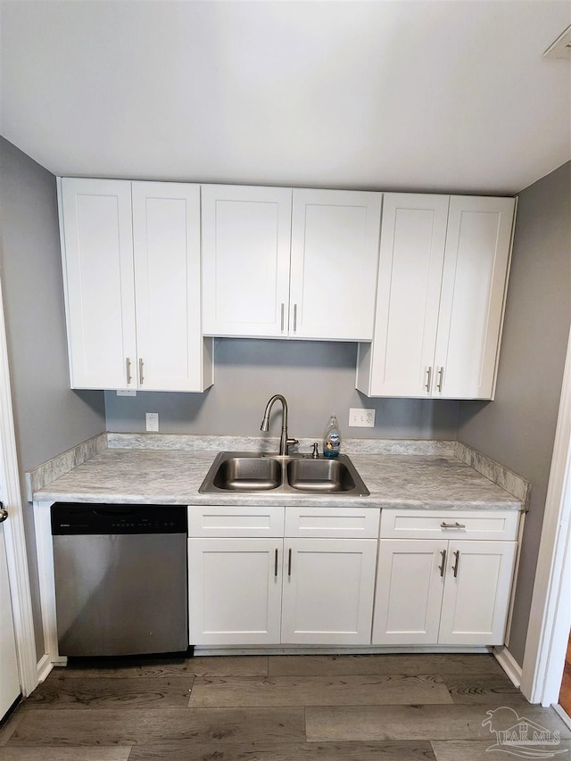 kitchen with stainless steel dishwasher, white cabinetry, sink, and dark wood-type flooring