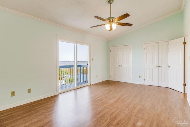 unfurnished bedroom with light wood-type flooring, multiple closets, ceiling fan, and ornamental molding