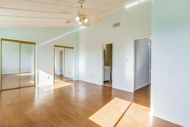 unfurnished bedroom with high vaulted ceiling, light hardwood / wood-style floors, ensuite bath, and ceiling fan