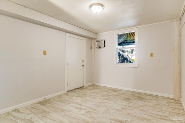 empty room featuring an AC wall unit and a textured ceiling