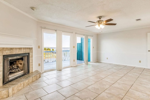 unfurnished living room with ceiling fan, crown molding, a textured ceiling, a fireplace, and light tile patterned flooring