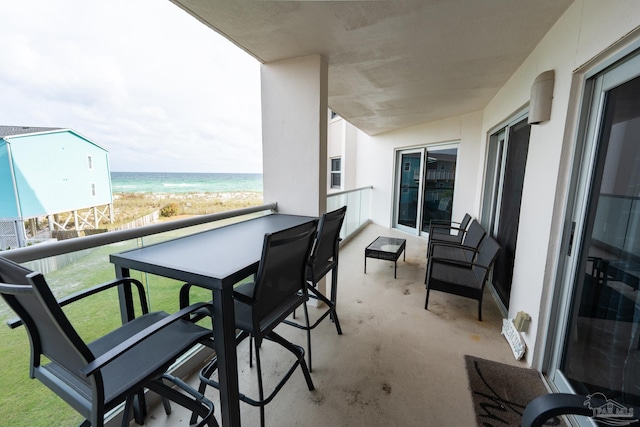 balcony featuring a beach view and a water view