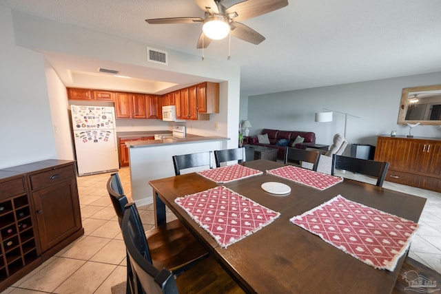 dining room with ceiling fan, light tile patterned flooring, and visible vents