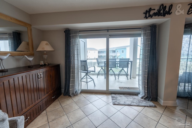 entryway with light tile patterned floors and baseboards