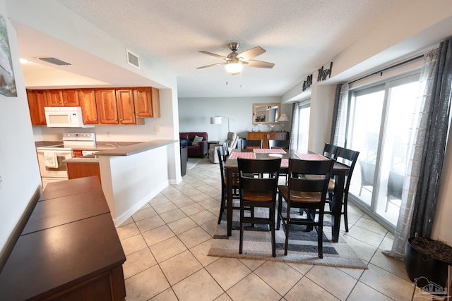 dining area featuring light tile patterned floors, visible vents, baseboards, and a ceiling fan