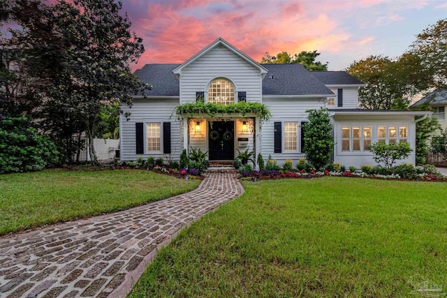 view of front of property with a front yard and a shingled roof