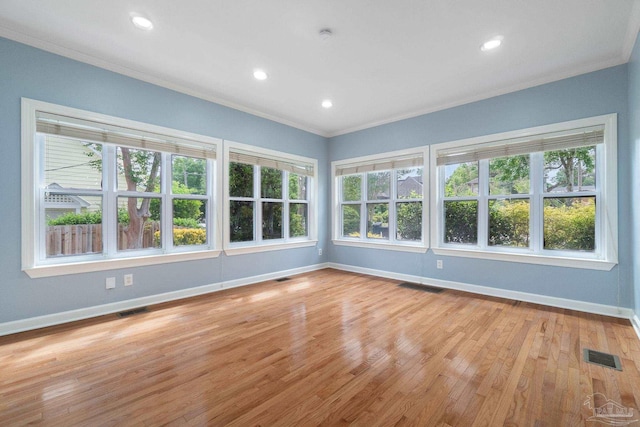 empty room featuring ornamental molding, visible vents, and baseboards