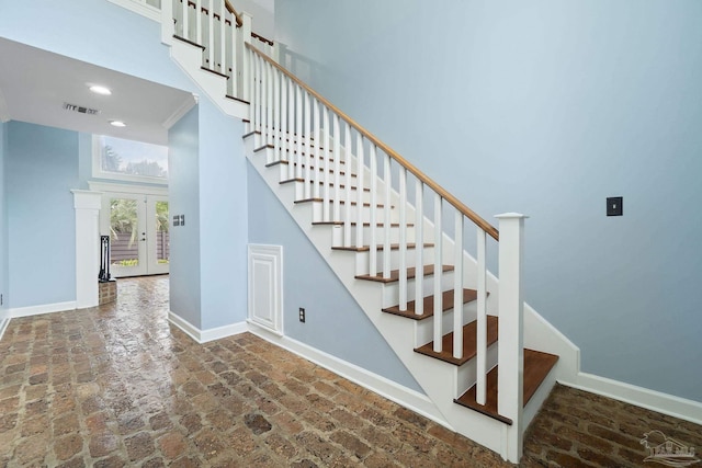 stairs with visible vents, baseboards, recessed lighting, french doors, and brick floor