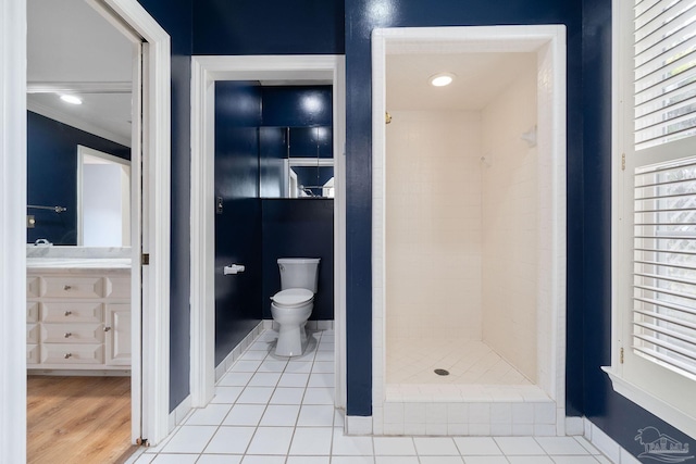bathroom with a shower stall, ornamental molding, toilet, vanity, and baseboards