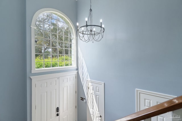 foyer with a notable chandelier, a high ceiling, and plenty of natural light
