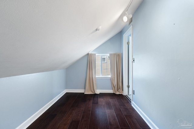 bonus room featuring baseboards, vaulted ceiling, and dark wood finished floors