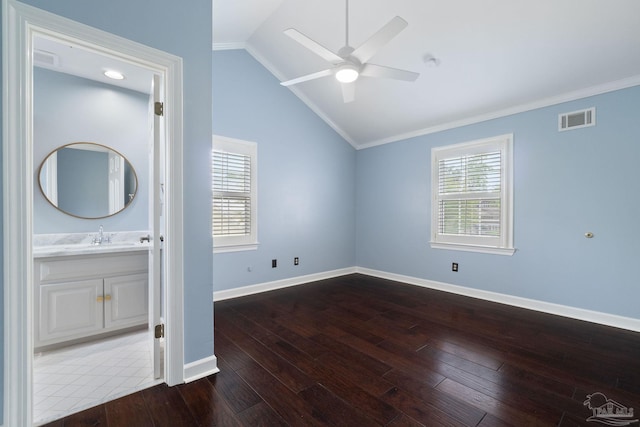 interior space with a ceiling fan, visible vents, ornamental molding, hardwood / wood-style floors, and lofted ceiling