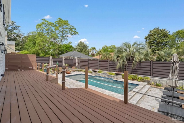 view of pool with a fenced in pool, a wooden deck, and a fenced backyard