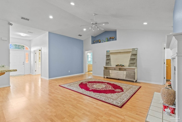 living room featuring light hardwood / wood-style flooring, ceiling fan, and high vaulted ceiling