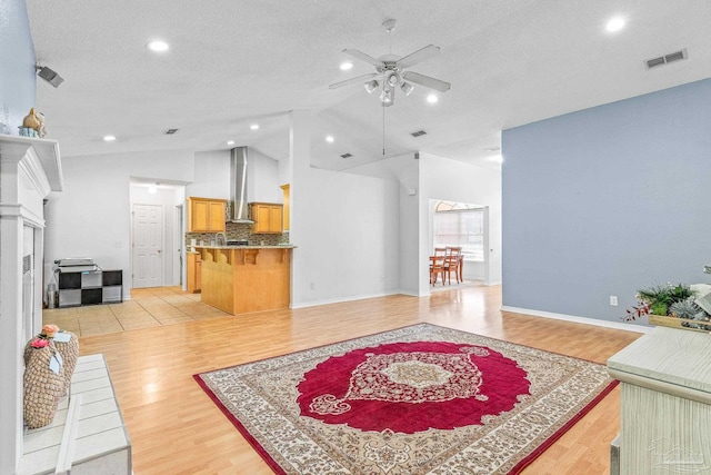 living room featuring a textured ceiling, light tile patterned floors, high vaulted ceiling, and ceiling fan