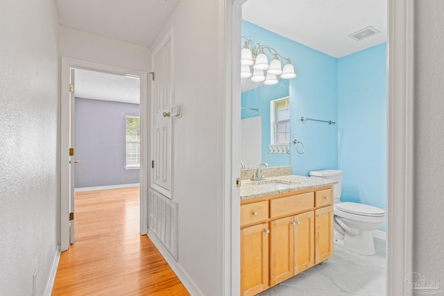 bathroom featuring wood-type flooring, toilet, and vanity