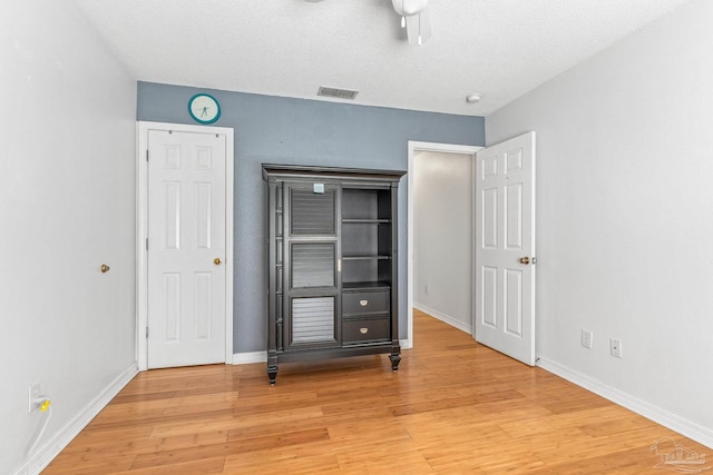 unfurnished bedroom with a textured ceiling, ceiling fan, and hardwood / wood-style floors