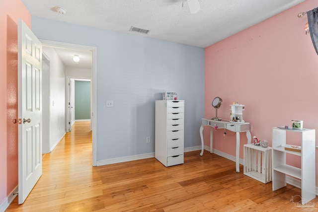 office with light hardwood / wood-style floors and a textured ceiling