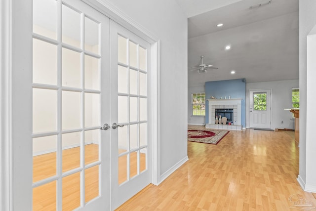 corridor with french doors and light hardwood / wood-style flooring