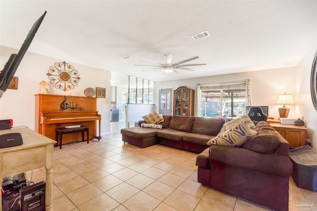 tiled living room with ceiling fan and a textured ceiling