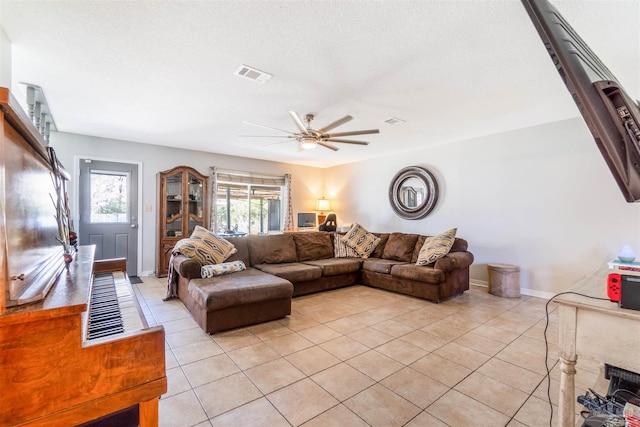 living room with ceiling fan, a textured ceiling, and light tile patterned floors