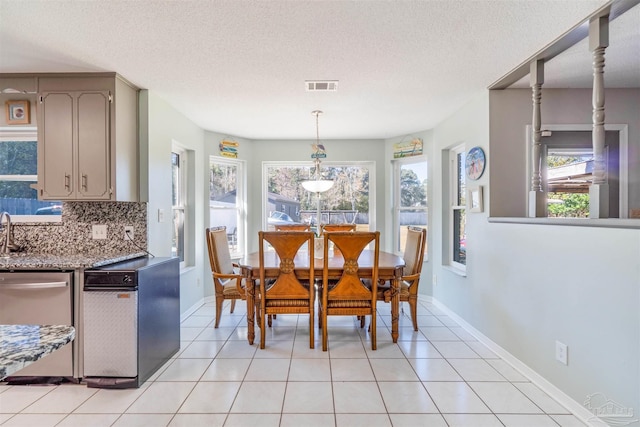 dining room with a textured ceiling and light tile patterned floors