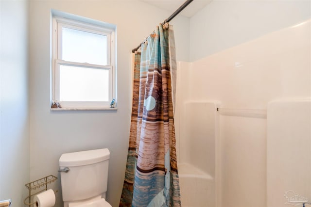 bathroom featuring a shower with curtain and toilet