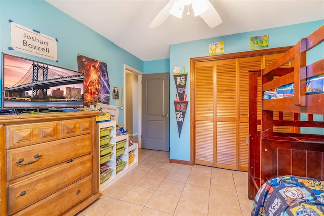 bedroom with light tile patterned flooring, a closet, and ceiling fan