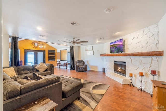 living room with hardwood / wood-style floors, french doors, a fireplace, vaulted ceiling, and ceiling fan