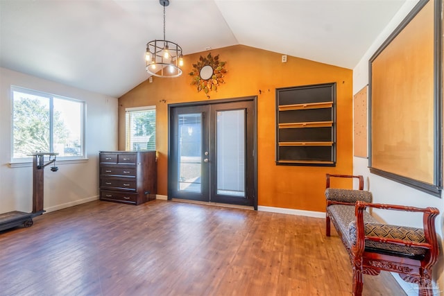 interior space featuring a notable chandelier, french doors, wood-type flooring, and lofted ceiling