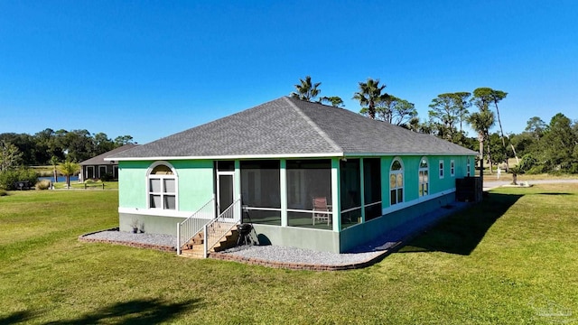 back of house featuring a yard and a sunroom