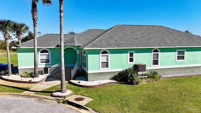 view of front facade with a front yard and central AC