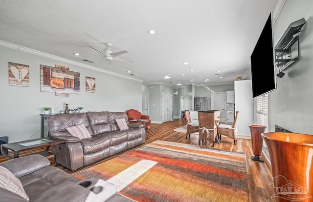 living room featuring crown molding, hardwood / wood-style flooring, and ceiling fan