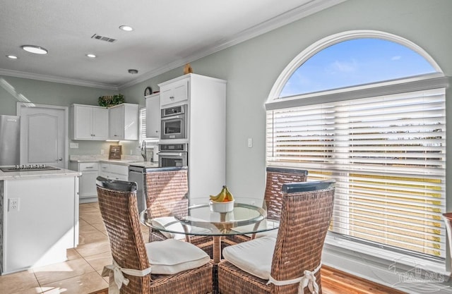 tiled dining space with ornamental molding and sink