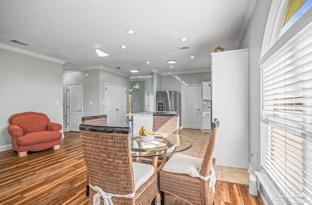 dining room featuring light hardwood / wood-style floors and ornamental molding