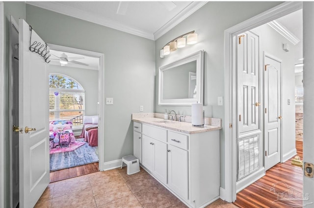 bathroom featuring vanity, ornamental molding, hardwood / wood-style flooring, and ceiling fan